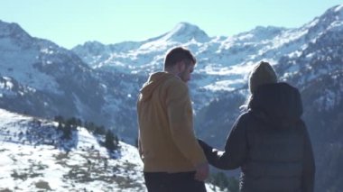 Karlı dağlarda kucaklaşan genç çift