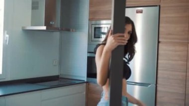 Genç esmer, seksi kadın odada poz veriyor.