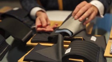 Kumaş örneklerine bakan hasat terzisi. 