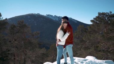 Genç çift kışın karlı ormanda aşık.