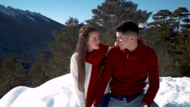 Genç çift kışın karlı ormanda aşık.