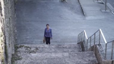 Şık çantalı zarif girişimcinin düşük açısı güneşli bir günde şehir caddesinde zorlu adımlar atıyor.