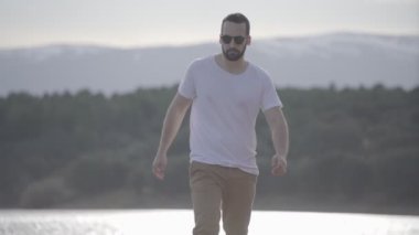 Genç adam dağlarda yürüyor.