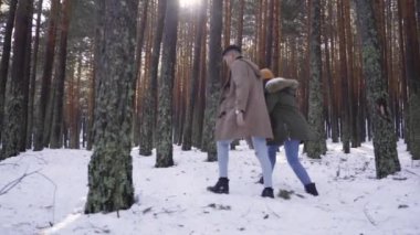 Genç çift kışın karlı ormanda aşık.