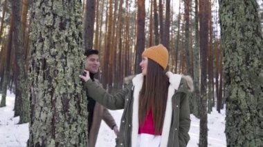 Genç çift kışın karlı ormanda aşık.