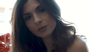 Genç esmer, seksi kadın odada poz veriyor.