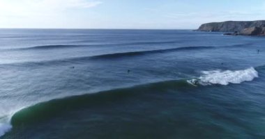 Okyanusta dalgaları yakalayan sörfçüler