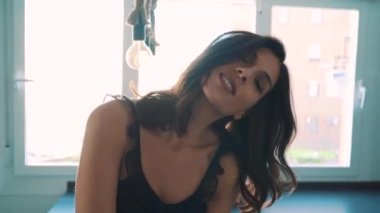 Genç esmer, seksi kadın odada poz veriyor.