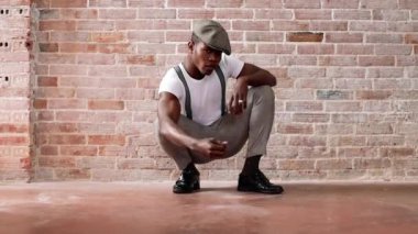 Siyahi adam oynuyor ve zarları yere atıyor.