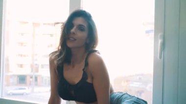 Genç esmer, seksi kadın odada poz veriyor.