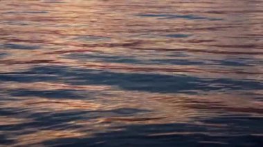 Gün batımında dalgalanan su 