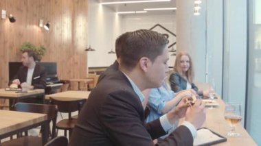 Mutlu arkadaşlar hamburgercide oturuyor.