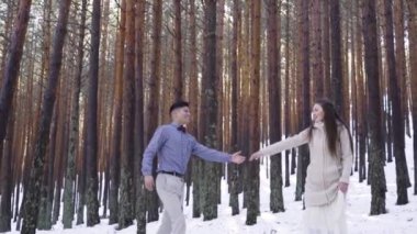 Genç çift kışın karlı ormanda aşık.