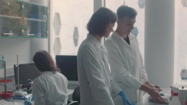 Laboratuvarda çalışan erkek ve kadın bilim adamları