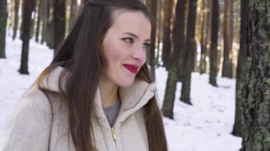 Genç ve mutlu bir kadın kış ormanında