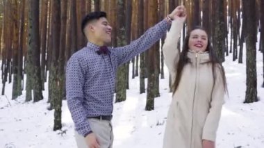 Genç çift kışın karlı ormanda aşık.