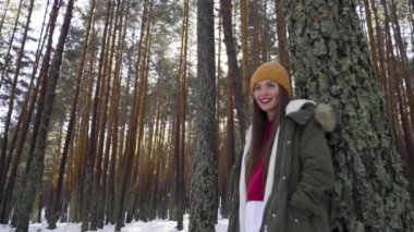 Genç ve mutlu bir kadın kış ormanında