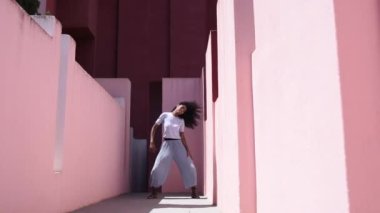 Black woman in a colorful building dancing 