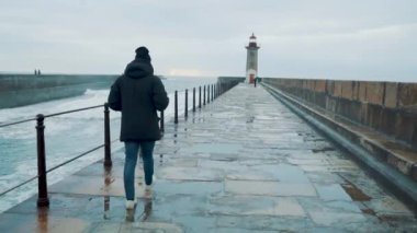 Şehirdeki deniz fenerinde yürüyen bir adam