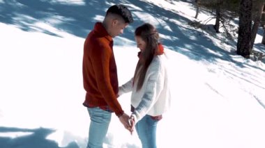 Genç çift kışın karlı ormanda aşık.
