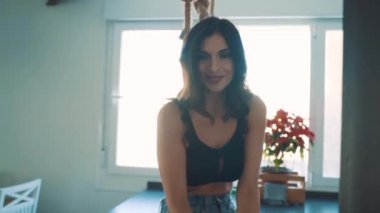 Genç esmer, seksi kadın odada poz veriyor.