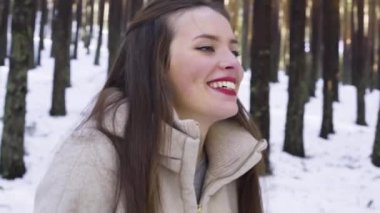 Genç ve mutlu bir kadın kış ormanında