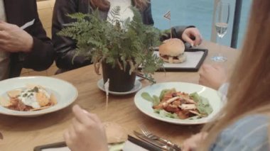 Mutlu arkadaşlar hamburgercide oturuyor.