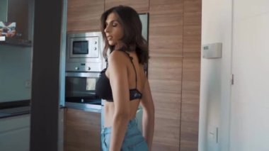 Genç esmer, seksi kadın odada poz veriyor.