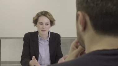 Genç bayan girişimci toplantı odasında erkek meslektaşıyla konuşuyor.