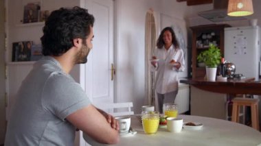 Genç çift kahvaltı yapıyor, romantik oynuyor ve gülüyor.