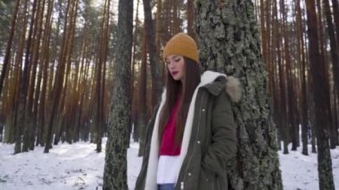 Genç ve mutlu bir kadın kış ormanında