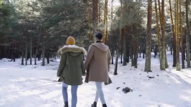 Genç çift kışın karlı ormanda aşık.