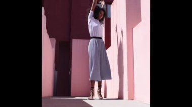Black woman in a colorful building dancing 