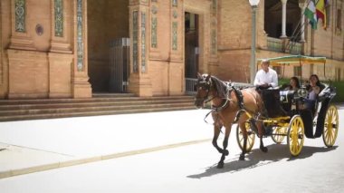 İspanya 'nın Sevilla şehrinde İspanya Meydanı' nda (Plaza Espana) at arabasıyla gezen Çinli turistler görülüyor.