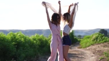 Yaz tarlasında yürüyen mutlu genç kadınlar