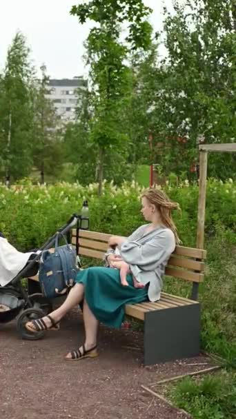 Młoda Kaukaska Matka Dredami Siedząca Dzieckiem Ławce Obok Wózka Odpoczywającego — Wideo stockowe