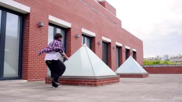 ジャンプとフリップを作る屋根の上の人 — ストック動画