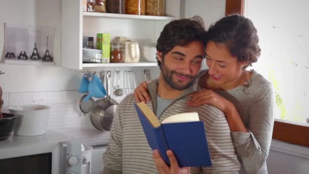 爱看书和在厨房里拥抱对年轻夫妇 — 图库视频影像