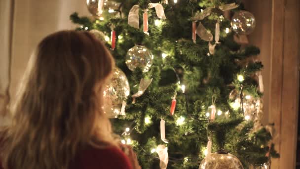 Mladá Žena Zdobí Vánoční Stromek Zlatými Skleněnými Kuličkami — Stock video