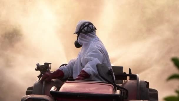 在有机农业农场驾驶拖拉机时 匿名农民身穿防护服 蒙面在柠檬树上喷洒杀虫剂和杀虫剂 — 图库视频影像