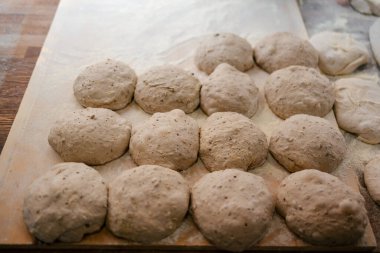 Fırında pişirilmeye hazır bir fırının masasındaki ekmek hamurunun portresi.