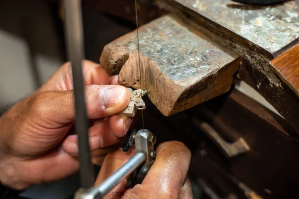Goldsmith working and creating in his crafting gold jewelry work
