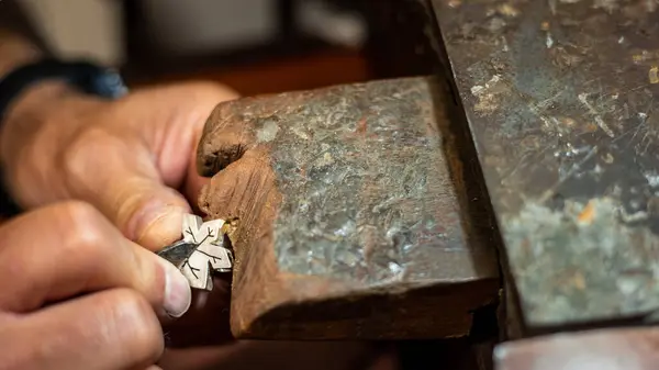 Goldsmith working and creating in his crafting gold jewelry work