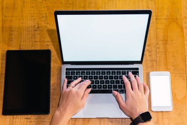 Yukarıdan gelen isimsiz kadın serbest bilgisayardan tablet ve akıllı telefonun yanında boş ekranla restoranda otururken