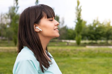 Spor yaptıktan sonra kulaklıklı beyaz bir kadının portresi. Sağlık ve sağlık..