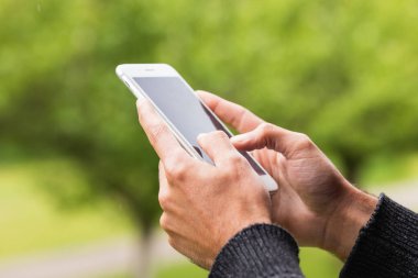 Pireneler 'de terasta dinlenirken akıllı telefondan tanınmayan bir erkeğin göz gezdirmesi.