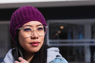 Sokakta mor şapkalı Asyalı bir kadının portresi.