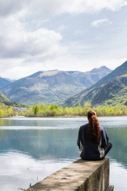 Tanımlanamayan bir kadın yolcunun, havuz kenarındaki iskelede oturması ve Pireneler 'in dağ sırasındaki özgürlüğünün tadını çıkarması.