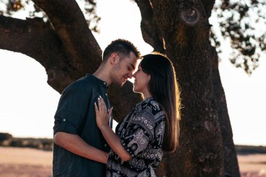 Genç çift kırsalda güzel ve güneşli bir günün tadını çıkarıyor. Öpüşüyorlar, sarılıyorlar, birlikte olmaktan mutlular.