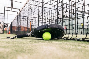 Tenis raketi ve top sahada.